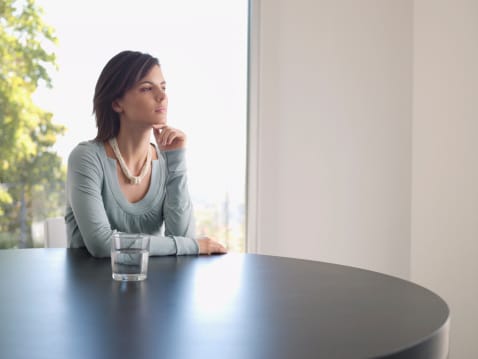 Serene woman reveling in her sober recovery with a glass of water.