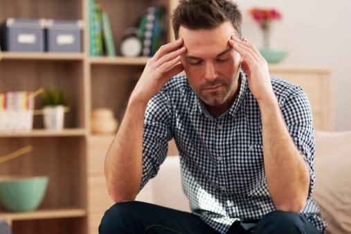 Man in checked shirt showing a headache -- definite sign of drug withdrawal.