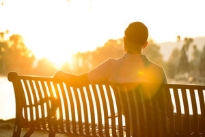 Man sitting on bench in sunshine of detox centers in South Florida