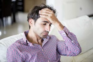 Man with hand to head wonders how long does heroin withdrawal last