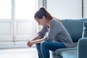 Sad woman on chair struggling with vicodin efffects